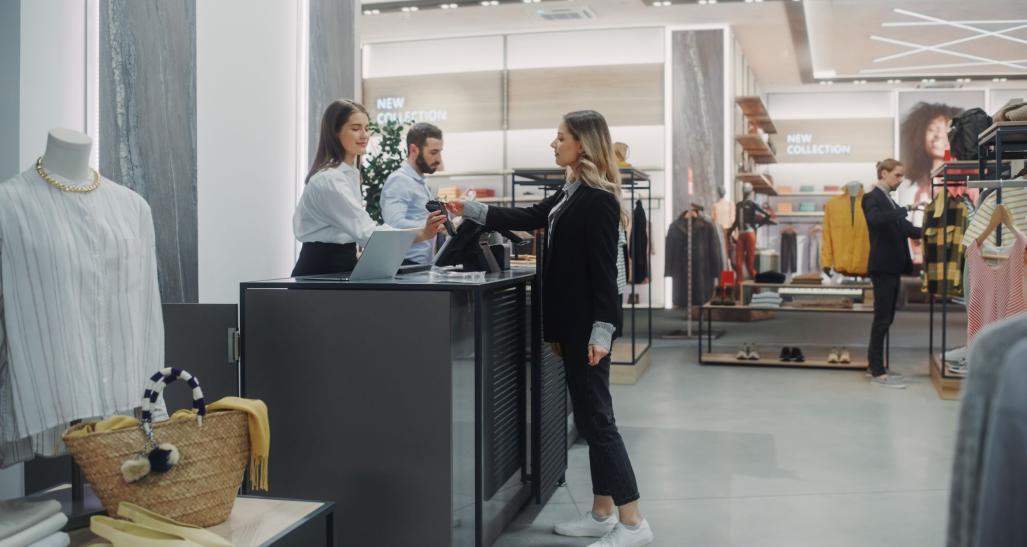 Woman checking out with credit card at a POS.