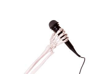 Skeleton arm holding a microphone.