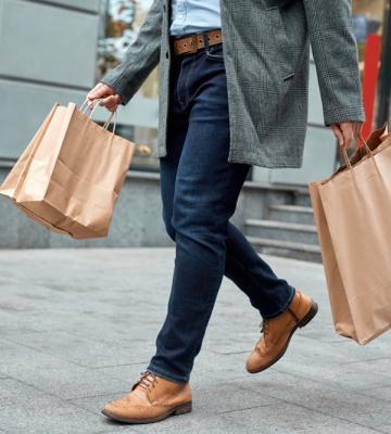 A man walking with multiple shopping bags.