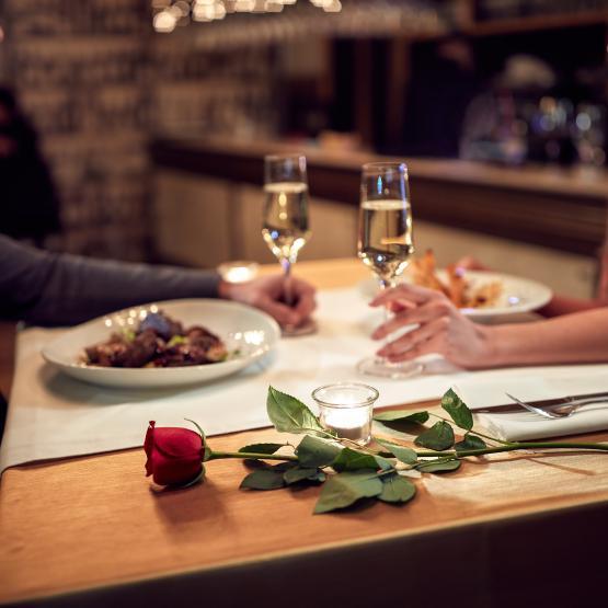 Dinner table with champagne and a rose and a candle.