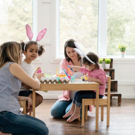 Mother's helping children paint Easter eggs.