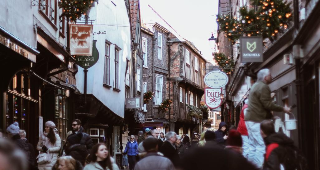 a town is shown during the holiday season with decorations and people shopping