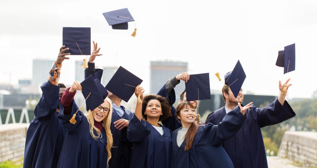 College students throwing caps in the air at graduation ceremony