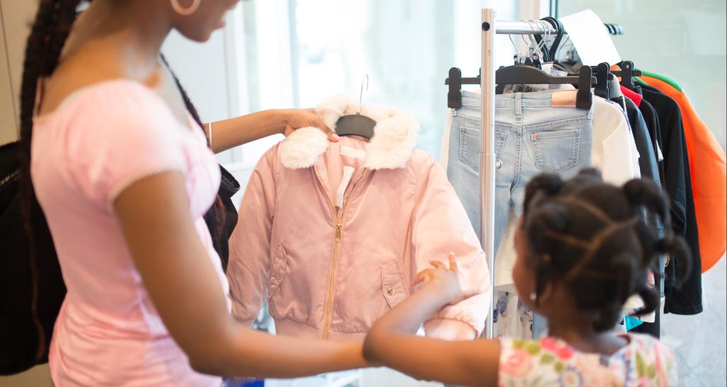 Mother and child look at coat in a store