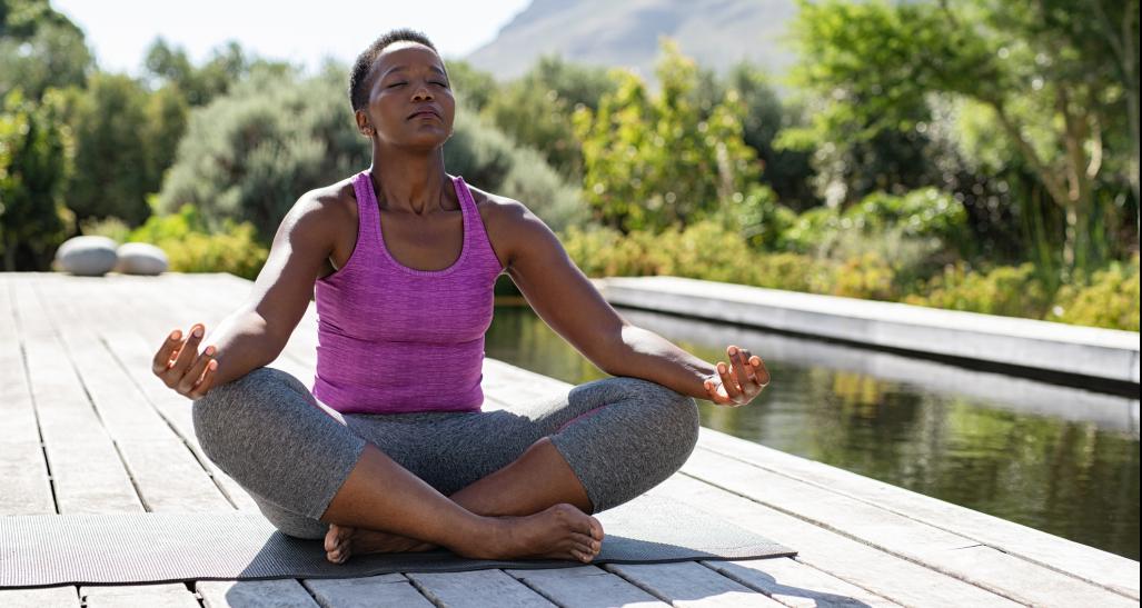 Woman in a yoga pose near the water