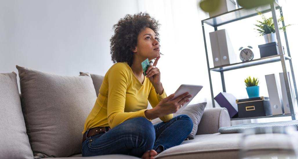 Woman shops on tablet from her couch