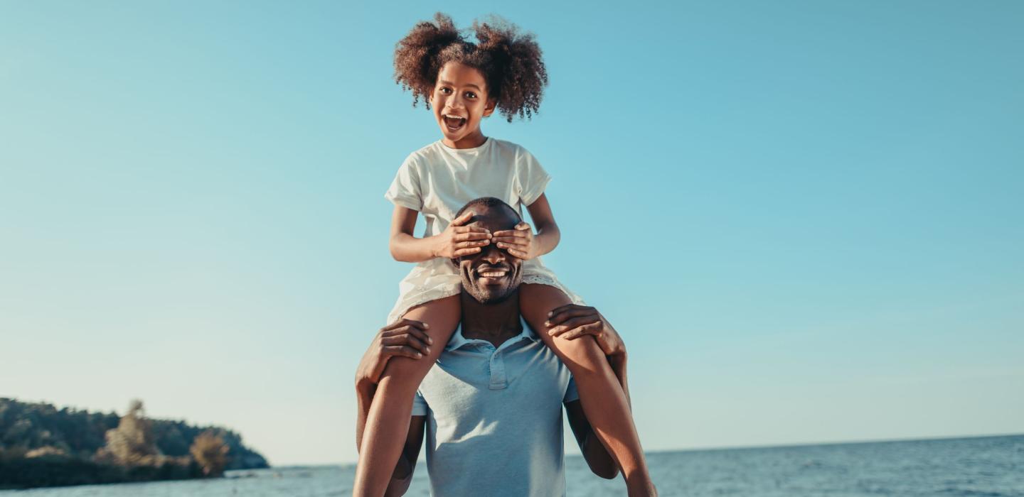 A father and daughter hang out on the beach together