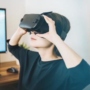 a woman has a headset on while viewing something via virtual reality