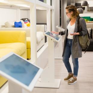 woman uses device in furniture store