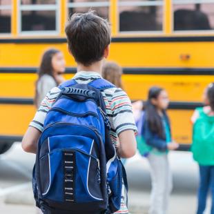 Boy waits to get on school bus