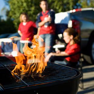 Three people in a parking lot tailgating