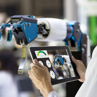 Man controlling robot in a manufacturing facility