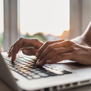 Man's hands typing on keyboard