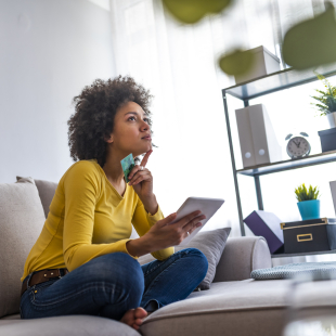 Woman shops on tablet from her couch