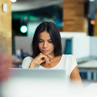 Woman works on computer in office